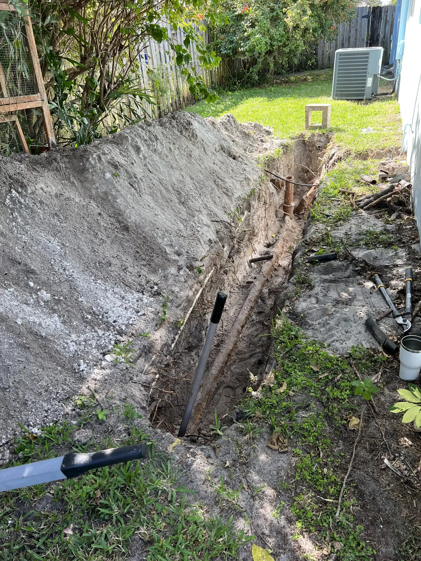 Excavated yard trench during cast iron sewer line replacement in Pompano Beach